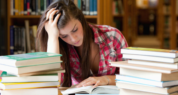 Focused student surrounded by books